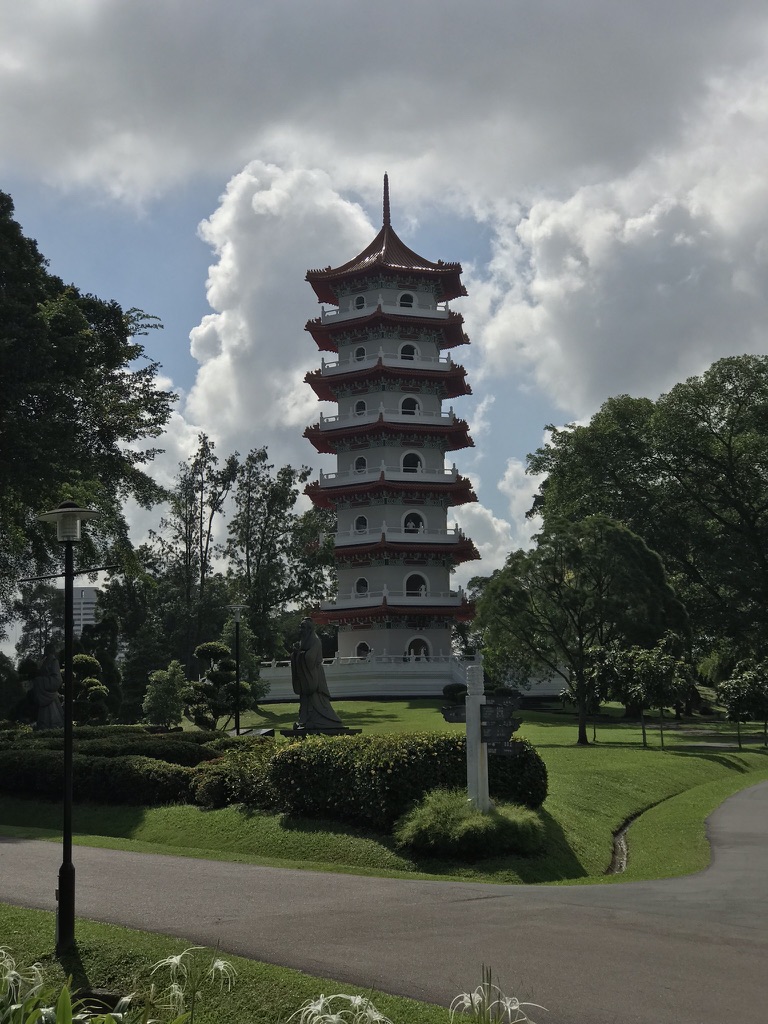 Seven-story pagoda rising above trees and gardens beneath large tropical clouds at the Chinese Garden in Singapore